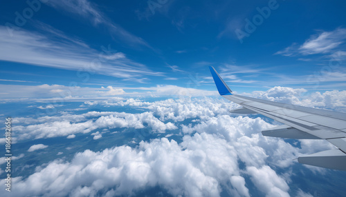  Soaring Skyward An airplane wing cuts through the vast expanse of a blue sky dotted with fluffy clouds, offering a breathtaking perspective of travel and freedom.