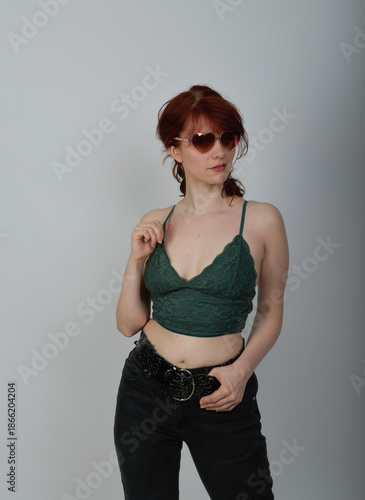 Stimmungsvolles Porträt einer jungen Frau in dunkler Atmosphäre mit seitlichem Licht. Die Pose und der direkte Ausdruck vermitteln Sinnlichkeit, Selbstbewusstsein und moderne Porträtästhetik.