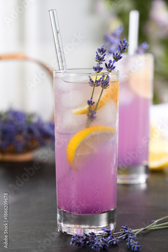 Refreshing lavender lemonade with ice, lemon slices, and fresh lavender sprigs in a tall glass. Summer drink with copy space, suitable for beverage, wellness, cafe, and lifestyle concepts.
