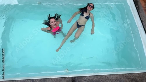 mãe e filha se divertem na piscina no verão  