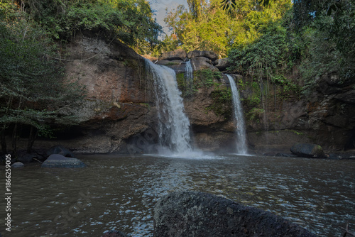 haew suwat waterfall cascading over rugged cliffs in khao yai national park, thailand — twin streams into shaded pool