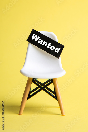 White chair with wanted sign representing job vacancy