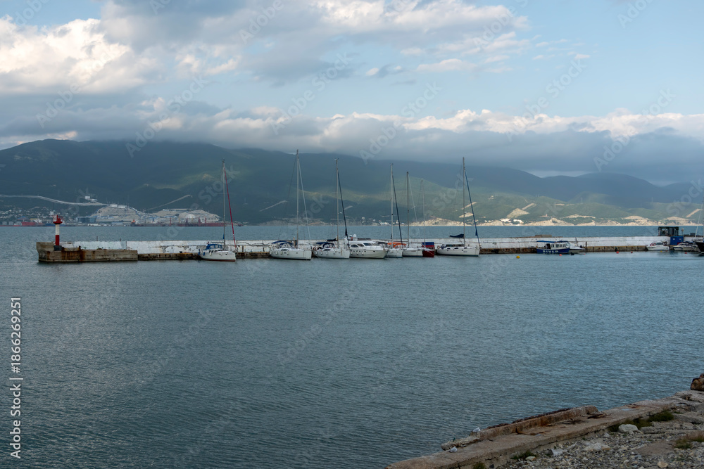 Fototapeta premium July 28, 2025: Yacht parking along the waterfront in Novorossiysk, Russia, with moored yachts near the coastline, reflecting maritime life and the Black Sea harbor atmosphere