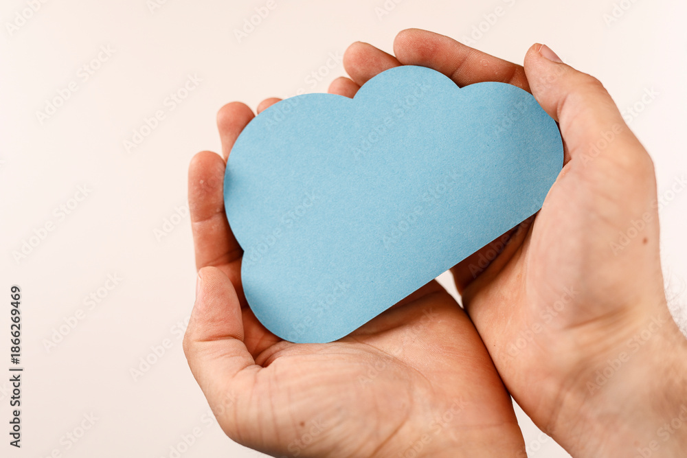 Obraz premium Hands holding a blue cloud shape. Concepts of technology, cloud computing, data storage, and protection. Symbolism of care, holding, and support