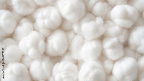 A close-up view of fluffy, white cotton balls, showcasing their soft texture and natural appearance against a neutral background.