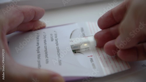 Inserting the test sample in the sample container into the pre paid envelope ready for sending to the Bowel Cancer Screening Programme for testing.