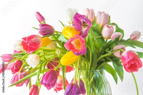 Valentines day or international womens day concept; bunch of colorful tulips in a vase on a white background
