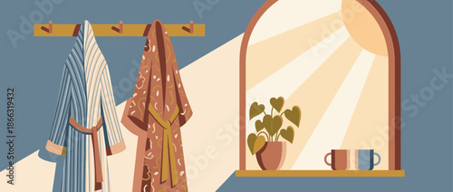 Two cozy bathrobes, one striped and one patterned, hanging on a wooden rack in a tranquil room with warm morning sunlight streaming through an arched window