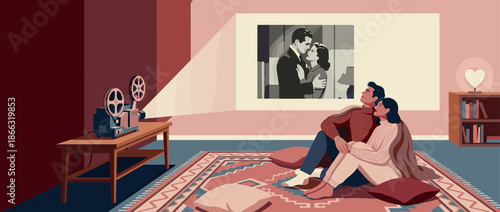 Romantic young couple in cozy sweaters sits on the floor watching a classic black and white movie from a vintage film projector in a cozy living room
