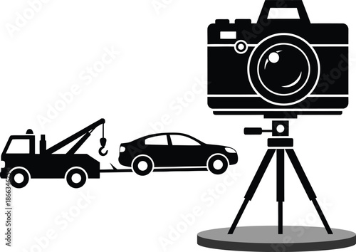Black and white of a car being towed by a tow truck with a camera on a tripod