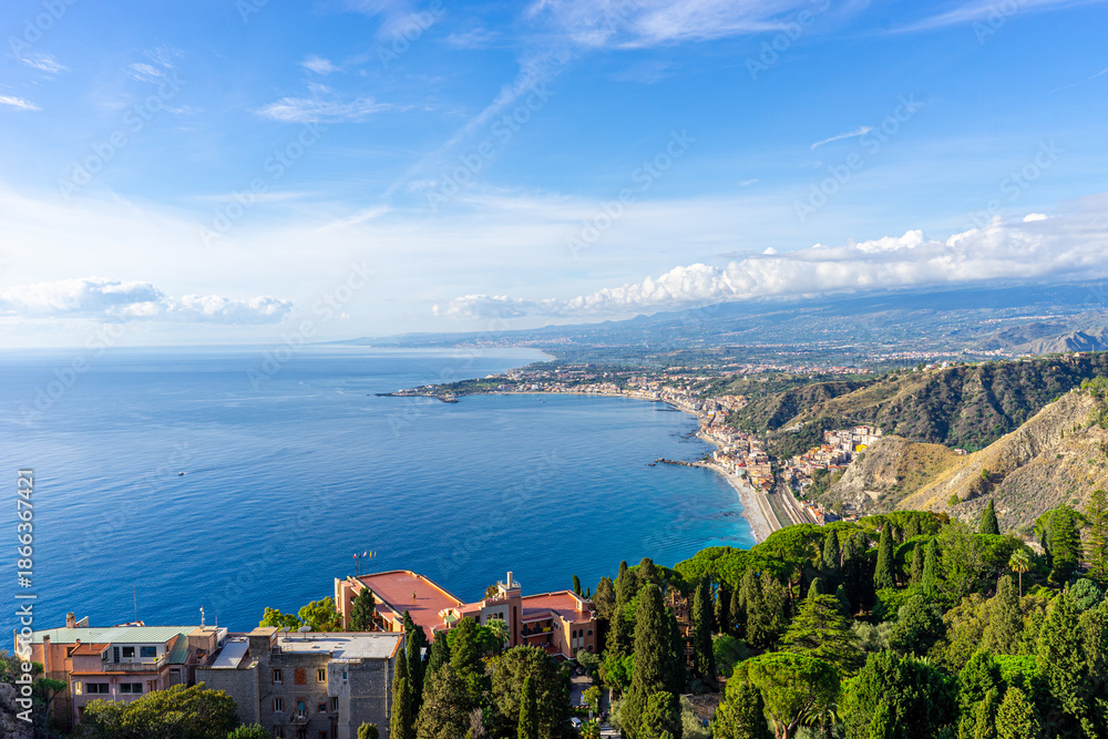 Fototapeta premium View across the bay between Taormina and Giardini-Naxos with Mount Etna in the background on the island of Sicily – Italy