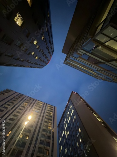Foto Looking up at modern buildings at night with a clear sky background