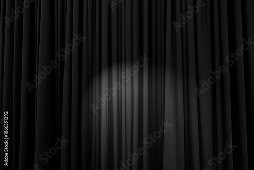 Background texture of black heavily corrugated curtain with stage light in the middle