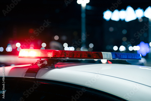  Close up view of flashing police car siren lights at night. Blue and red police lights as background .