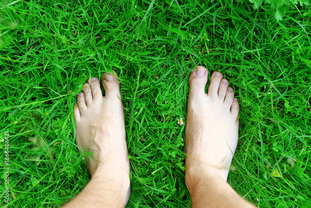 Obraz premium Carefree woman standing barefoot on fresh grass