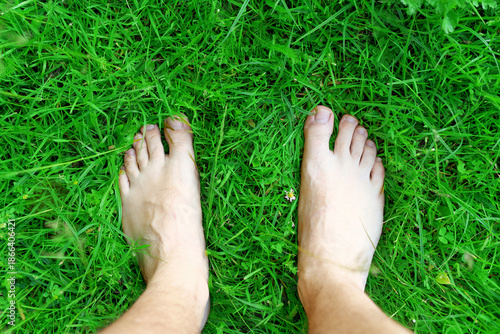 Carefree woman standing barefoot on fresh grass