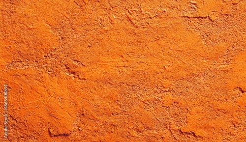 Textured close-up of a weathered orange surface, showing cracks and unevenness