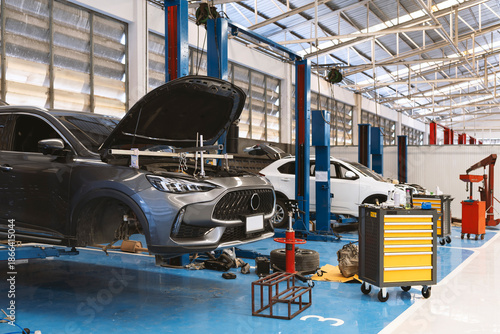 Car engine supported by a steel hanger bar during repair service