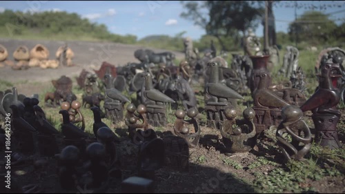 Slow motion slo mo outdoors and outside of small hand-crafted bird statues and sculptures with iconic soapstone carvings from Great Zimbabwe in an African culture representing royalty, spirituality