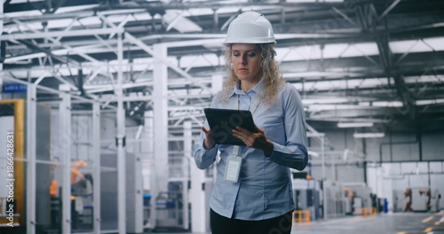 Wallpaper Mural Professional Female Engineer in Hard Hat Checks Production Data on Tablet While Walking Through Modern Automated Factory. Concept of Smart Manufacturing, Industry 4.0, Digital Control and Efficiency. Torontodigital.ca