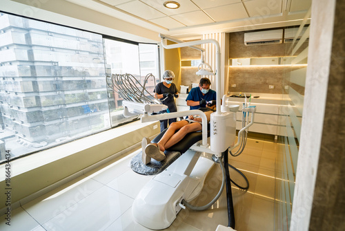 Young woman receiving preventive dental treatment at clinic