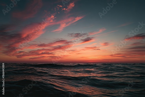 Dramatic sky ablaze with fiery hues reflecting on churning ocean waters at dusk