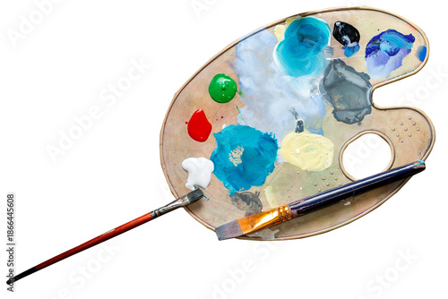 Palette with multi-colored paints and brushes top view