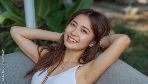 Young Woman Smiles While Relaxing on Sofa in Outdoor Setting During Daytime