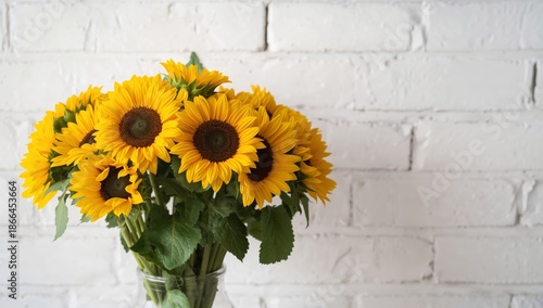 Sunflowers in a Clear Vase on a White Brick Wall Indoors During Daylight