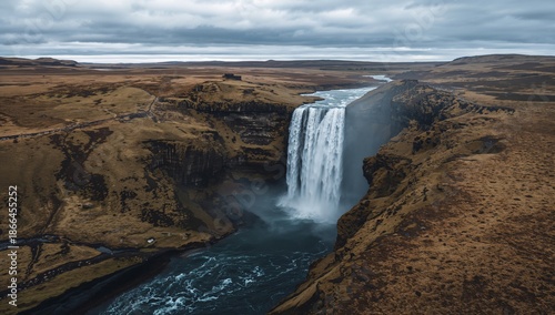 Waterfall Cascades Down Rocky Cliffs in Iceland, Surrounded by Open Land and ...