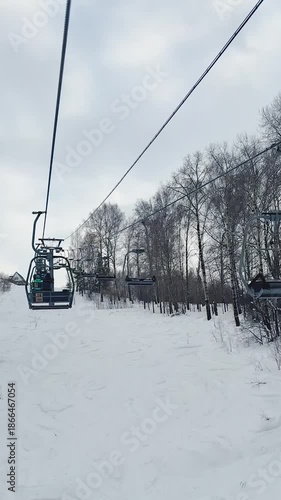A chairlift for two at the ski resort. Vertical footage