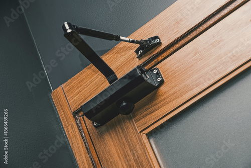 Wallpaper Mural Close up of a black hydraulic automatic door closer installed on the top of a wooden door frame. Security and convenience hardware. Torontodigital.ca