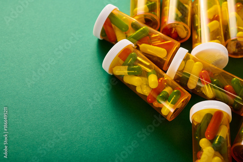 Pills in orange plastic bottles on a green table.