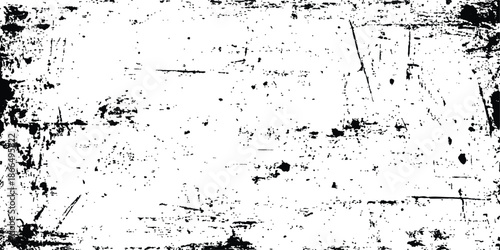 A high-contrast grunge texture overlay with distressed black speckles and scratches. Abstract grunge texture with sharp black scratches and distressed lines on a white background. textured background.