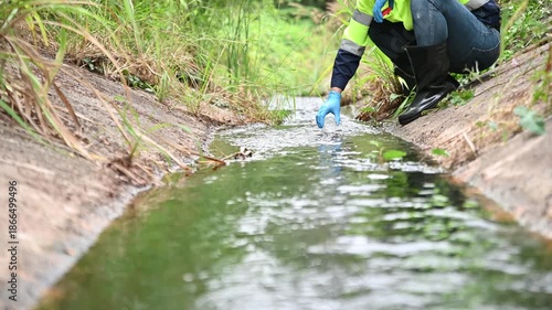 Environmental Inspector Collecting Water Sample from Stream for Quality Testing and Safety Assessment