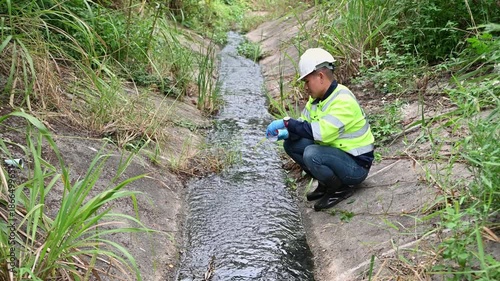 Environmental Inspector Collecting Water Sample from Stream for Quality Testing and Safety Monitoring