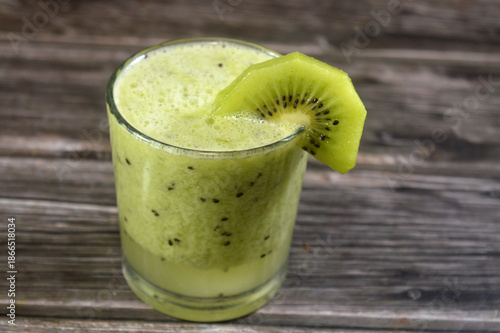 smoothie juice of Kiwifruit kiwi, an edible berry from woody vines, with fuzzy brown skin, bright green flesh, tiny black seeds, and sweet-tart flavor, packed with Vitamin C, fiber, antioxidants