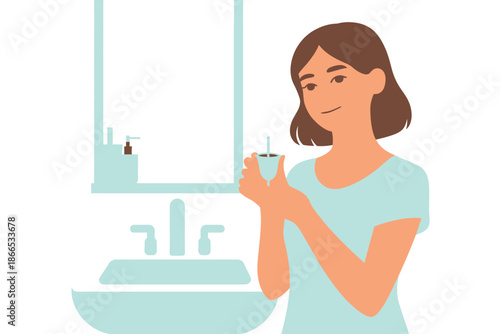 Woman holding a menstrual cup in the bathroom with a sink and mirror in the background.