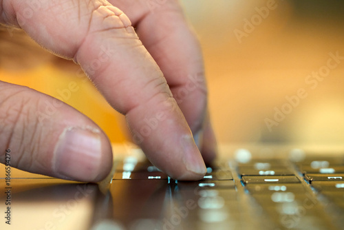 Hand typing on a keyboard while working