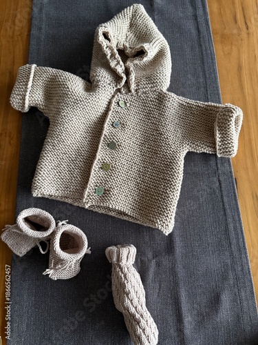 DIY Knitten baby clothes on a wooden background