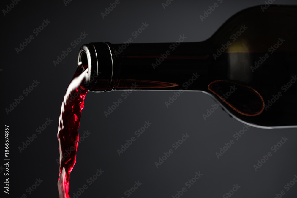 Fototapeta premium Red wine pours out of the bottle.