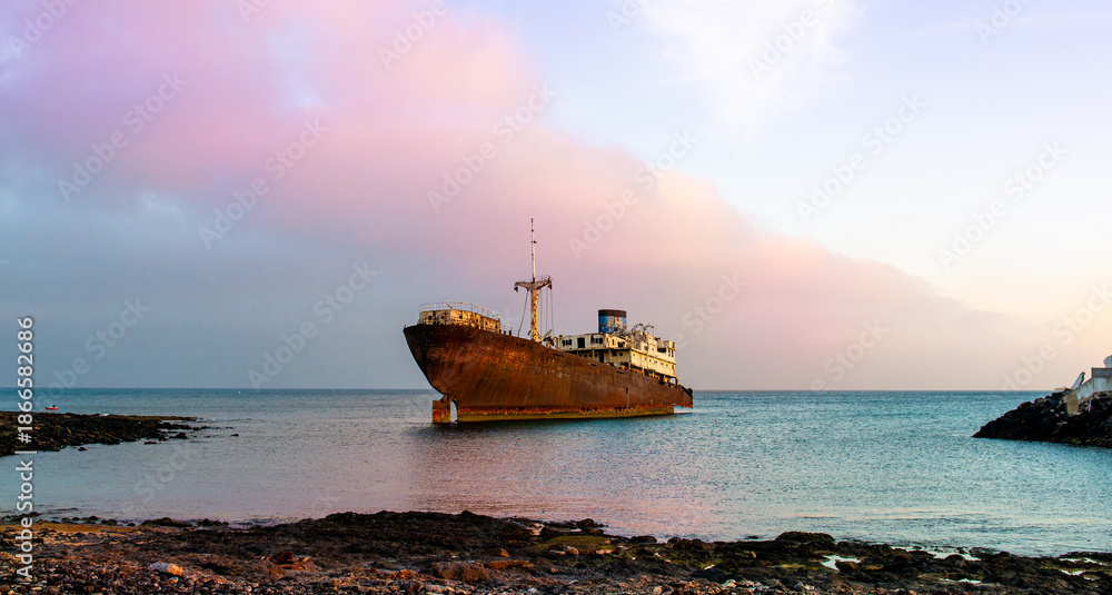 Fototapeta premium Rusty Abandoned Ship Sitting By The Seashore
