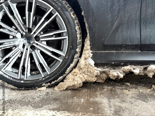 Quadro su tela Car wheel with alloy rim spinning through slush and mud, close-up of tire motion, wet splash textures, winter road surface detail, dynamic low angle, transport and weather conditions concept