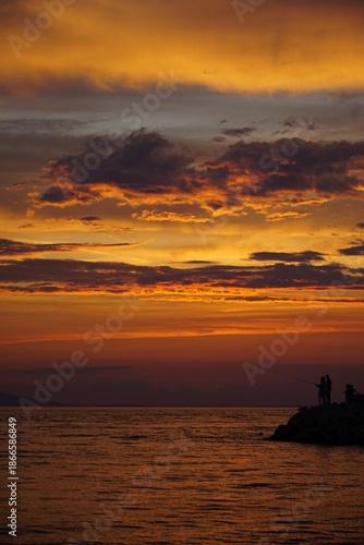Beautiful fiery ocean sunset with red and orange glow on rippling sea surface