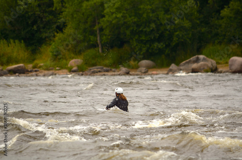 A woman is floating down a turbulent river in a boat