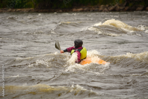 A man is floating down a turbulent river in a boat
