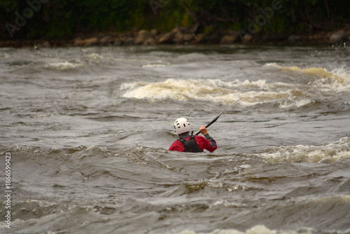 A man is floating down a turbulent river in a boat