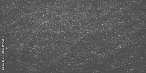 A dark and textured closeup of grey asphalt shows a rough stone surface where raindrops create an abstract grunge pattern on the black street road