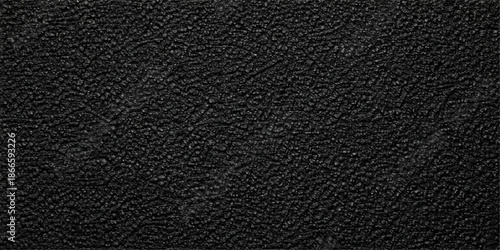 A dark macro shot of a black leather texture background features a natural rough pattern on a textured skin surface, creating a close-up material design for a textile backdrop or wallpaper