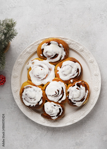 Christmas tree shape glazing cinnamon rolls or cinnabon buns on white plate. Top view.